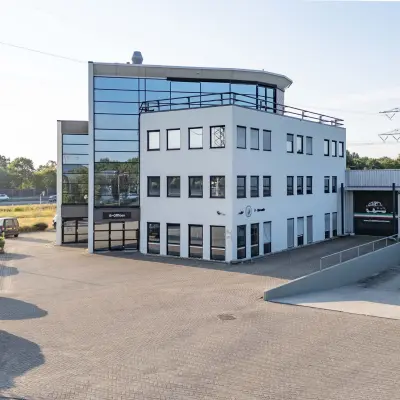 Exterior view of office space for rent at Keizersveld 47, Venray, featuring a modern building with parking area.