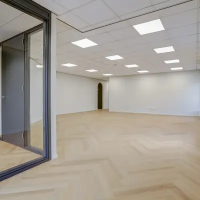 Unfurnished office space at Keizersveld 47, Venray, available for rent with large windows and wooden flooring, ideal for customization.