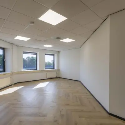 Bright office space with large windows and wooden flooring, ideal for rent office space in Venray.