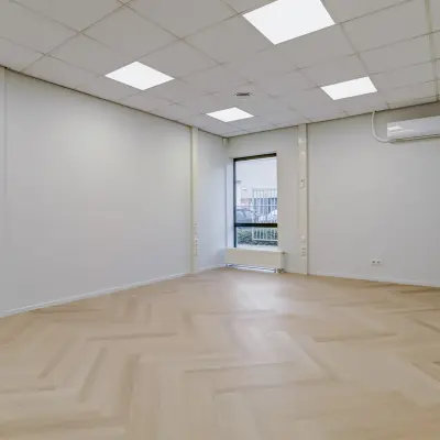 Bright office space available for rent at Keizersveld 47, Venray, featuring wooden flooring and natural lighting through large windows.