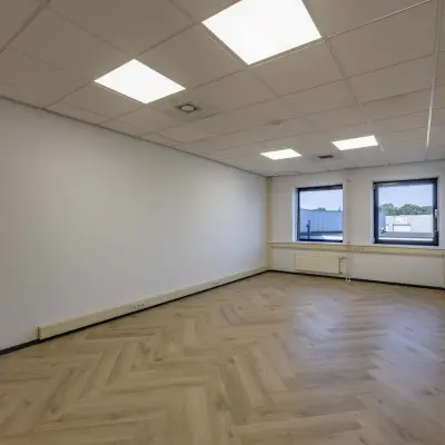 Spacious unfurnished office space with parquet flooring and large windows at Keizersveld 47 in Venray, ideal for office space rental.