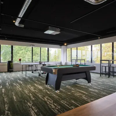Spacious office space at Havenweg 24, Vianen Utr, featuring a sleek pool table and large windows overlooking greenery, perfect for a modern office space rental.