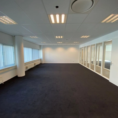 Spacious office to rent at Regulusweg 11, Voorburg, featuring large windows, neutral decor, and ample lighting, ideal for versatile workspace configurations.