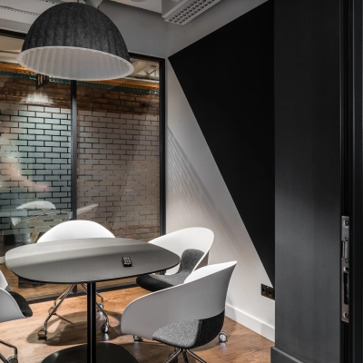 Modern office space rental at Konstruktorska 11, Warsaw Mokotow, featuring a small meeting area with stylish chairs and a round table.