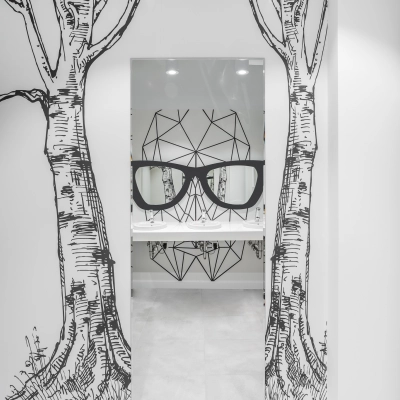 Stylish office restroom at Konstruktorska 11, Warsaw Mokotow with artistic wall designs and modern fixtures. Perfect for office space rental.