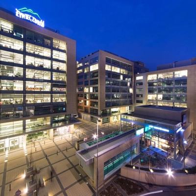 Overview of the modern office complex at Postępu 17A, Warsaw Mokotow, ideal for office space rental with illuminated buildings in the evening.