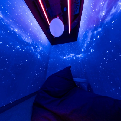 A furnished space at Al. Jerozolimskie 181B, Warsaw Ochota, with starry blue walls and a comfortable bean bag chair, ideal for office space rental.