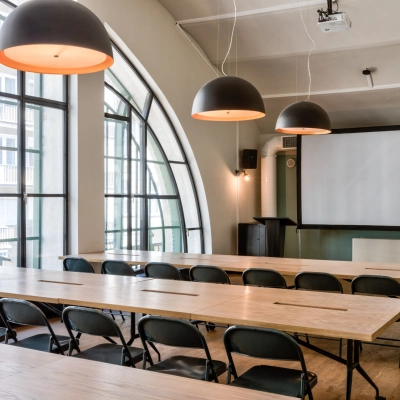 Spacious, well-lit conference room at Koszykowa 61, Warsaw Śródmieście, ideal for office space rental, featuring large windows, modern lighting, and ample seating for productive meetings.