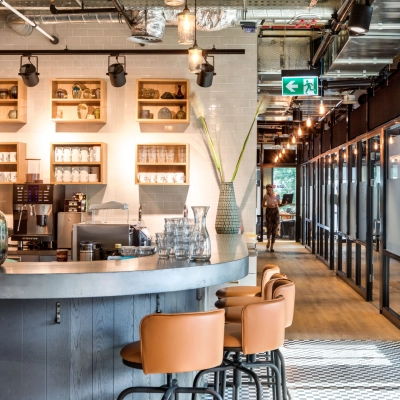Modern furnished office space for rent at Koszykowa 61, Warsaw Śródmieście, featuring a stylish open-floor plan with sleek lighting and bar seating.