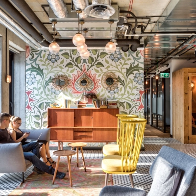 Modern office space rental in Warsaw Śródmieście at Koszykowa 65. Features stylish furnishings with people engaged in a business meeting on comfortable chairs.