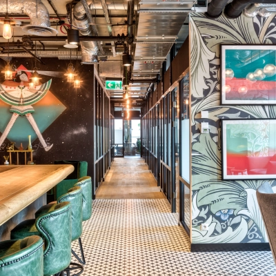 Modern office space with stylish decor, featuring green chairs and artwork on the walls, perfect for office space rental at Koszykowa 65, Warsaw Śródmieście.