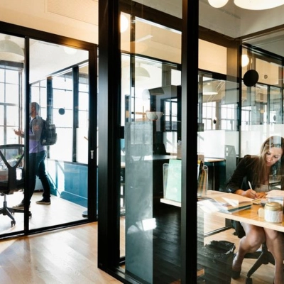 Business activities in a furnished office to rent on Krakowskie Przedmieście 13, Warsaw Śródmieście, showcasing modern workspaces with people engaged in discussions and work.