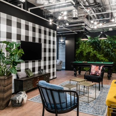 Stylish office space in Warsaw Śródmieście featuring cozy seating, a checkerboard wall, and a pool table, ideal for office space rental.