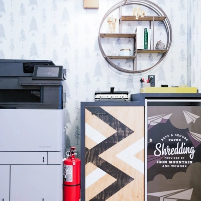 Furnished office space rental at Grzybowska 60 in Warsaw Wola featuring printing equipment and decorative shelving.