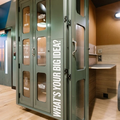 Inviting office space rental at Grzybowska 60 in Warsaw Wola, featuring a stylish booth area with vibrant decor, perfect for creative work sessions. Ideal office to rent with modern furnishings.