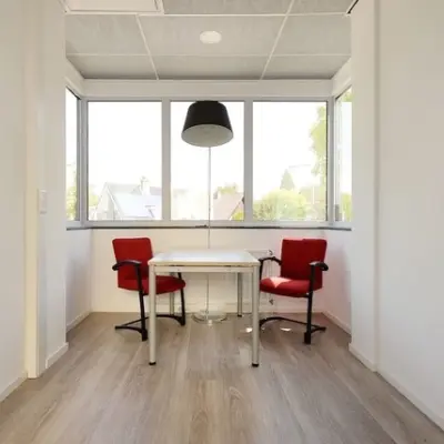 Bright office space with two red chairs and a table, ideal for office space rental at Molenweer 2, Wateringen.