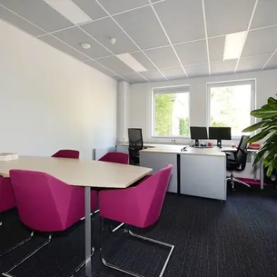 Bright office space at Molenweer 2, Wateringen, featuring modern desks, vibrant chairs, and large windows. Ideal for those seeking office space rental with natural light.