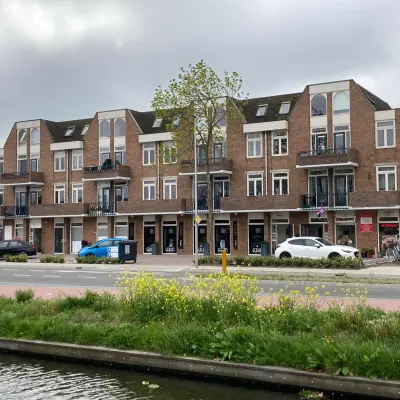 Exterior view of an office building at Boerendijk 8 in Woerden, showing multiple storefronts and parking options. Ideal spot for office space rental.