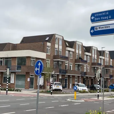 Exterior view of office building for rent at Boerendijk 8, Woerden, showing multiple levels with brick facade and parking area.