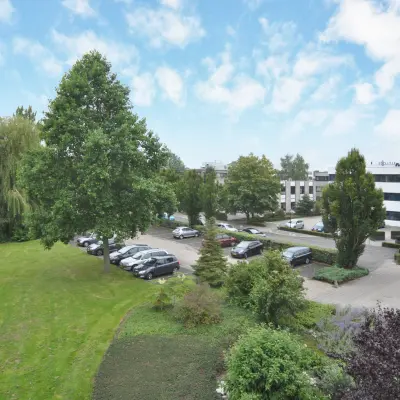 View of the office building and parking area at Houttuinlaan 4, Woerden, ideal for office space rental.