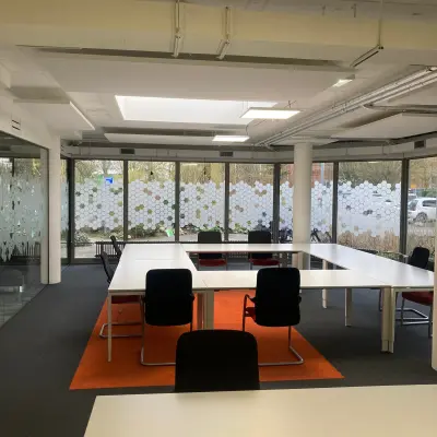 Bright office space with large windows and modern furnishings available for rent at Houttuinlaan 4, Woerden.