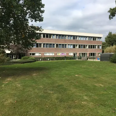 Exterior view of the office building located at Houttuinlaan 4, Woerden, ideal for rent office space with spacious lawn.
