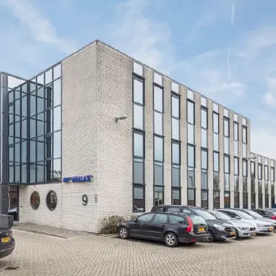 Exterior view of a modern office building at Pompmolenlaan 9, Woerden, offering office space rental with ample parking.