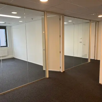 Spacious office space with glass partitions and carpet flooring at Pompmolenlaan 9, ideal for rental.