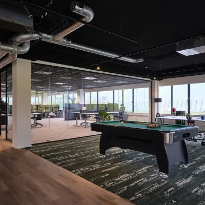 Spacious office at Vijzelmolenlaan 9, Woerden, featuring open-floor workspaces and a recreational area with a pool table. Ideal for office space rental.