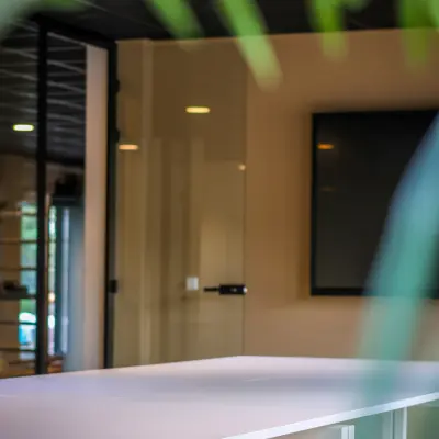 Modern office space with white tables and a large screen, suitable for workspaces available for office space rental.