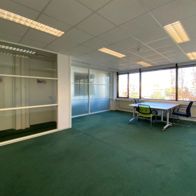 Spacious office space for rent at Zaagmolenlaan 4, Woerden, featuring large windows and table with chairs, ideal for business activities.