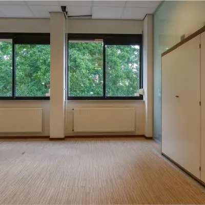 Office space available for rent at Bredewater 26, Zoetermeer, featuring large windows and a built-in storage cabinet.