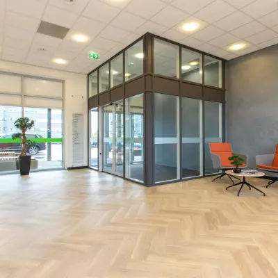 Spacious office entrance at Louis Braillelaan 80, Zoetermeer, showcasing modern design with a reception area and seating. Perfect for office space rental needs.