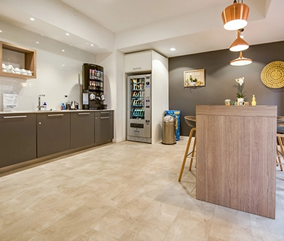 Modern office space at Badenerstrasse 47, Zürich Center featuring a furnished lounge area with a high table and chairs, ideal for office space rental.