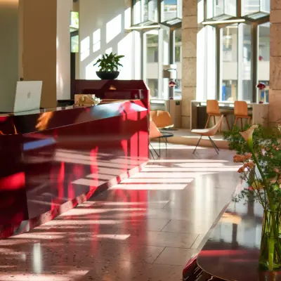 Bright Zürich Center office featuring a glossy reception desk, modern furnishings, and natural light ideal for office space rental.