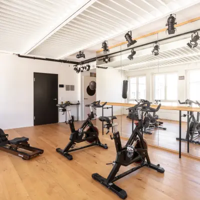 A modern fitness area located at Talacker 41, Zürich Center with wooden floors, mirrors, and exercise equipment, ideal for those seeking office space rental with amenities.