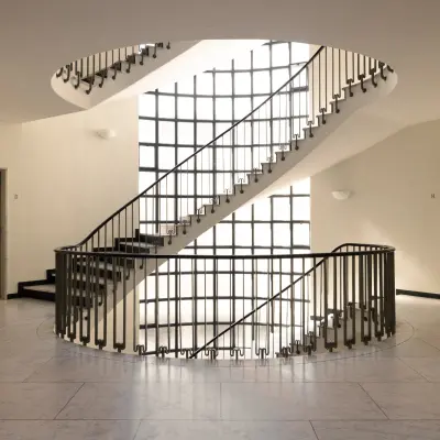 Spiral staircase with frosted glass doors at Talacker 41 in Zürich Center, offering unique office space rental opportunities.