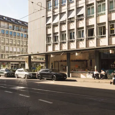 Exterior view of Talacker 41 in Zürich Center, featuring nearby parked cars and people outside the Boreal Coffee shop.