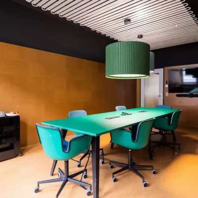 Stylish conference room at Uraniastrasse 31, Zürich Center, featuring vibrant green chairs and a large table, ideal for office space rental.