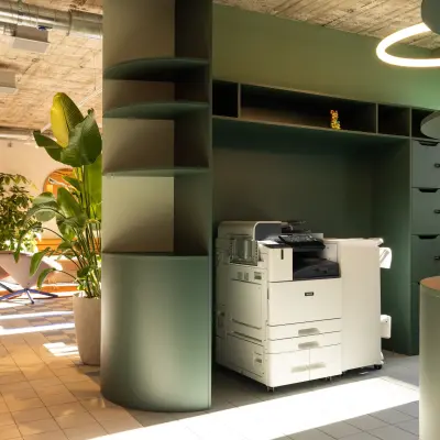 Modern workspace at Beethovenstrasse 48, Zürich Enge featuring stylish green cabinetry and a multifunction printer under natural lighting, ideal for office space rental.
