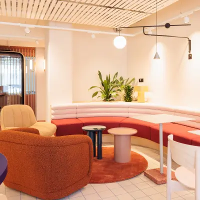 Stylish furnished office space rental at Stockerstrasse 33 in Zürich Enge features modern seating and vibrant decor.