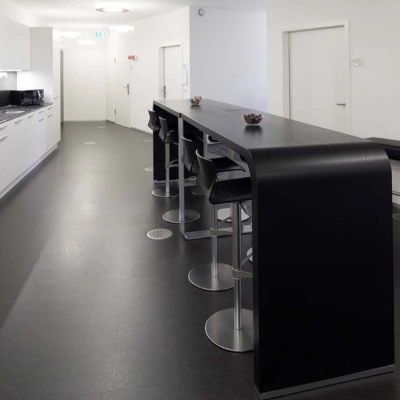 Modern office space with sleek kitchen facilities and high-top seating at Europaallee 41, perfect for office space rental in Zürich Mitte.