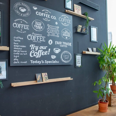 Interior of an office space at Assendorperdijk 1, Zwolle, featuring a black wall with coffee-themed decor and potted plants, suitable for office space rental.