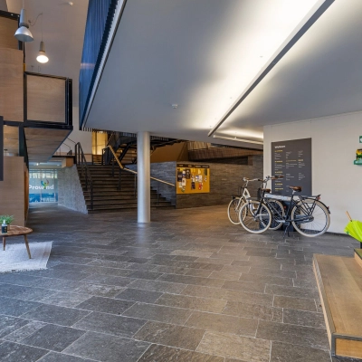 Spacious entrance area at Assendorperdijk 1, Zwolle, ideal for office space rental, featuring a sleek modern design with bicycles parked nearby.