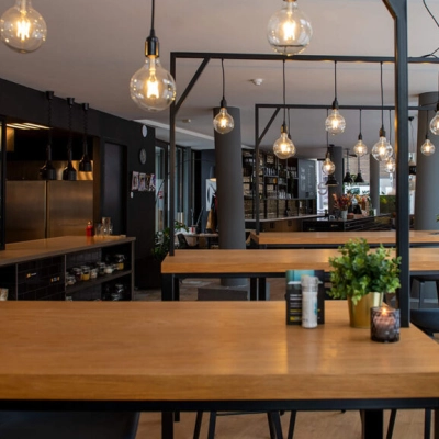 Modern office space rental in Zwolle with wooden tables and stylish lighting, offering a practical environment for business activities at Assendorperdijk 1.