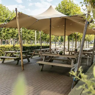 Outdoor office space rental at Hanzeplein 11-27, Zwolle, featuring picnic tables under a canopy, ideal for informal meetings or breaks.