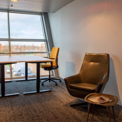 A furnished office space with chairs and desks by a large window at Zwartewaterallee 48, Zwolle, ideal for office space rental.