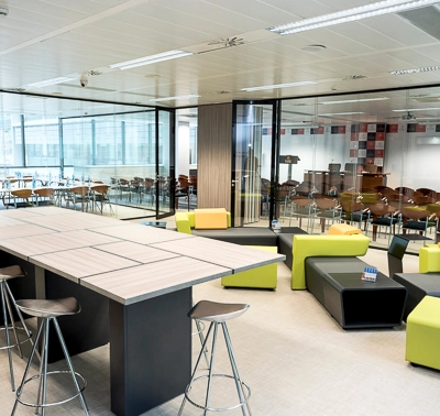 Moderna oficina en Carrer de Llull 321, Barcelona, con mobiliario colorido y espacios abiertos ideales para alquilar una oficina. El ambiente es luminoso y está preparado para reuniones y trabajo colaborativo.