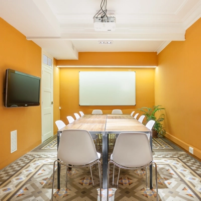 Sala de reuniones luminosa con una gran mesa y sillas metálicas, ideal para alquilar una oficina en Barcelona Eixample, Rambla de Catalunya.