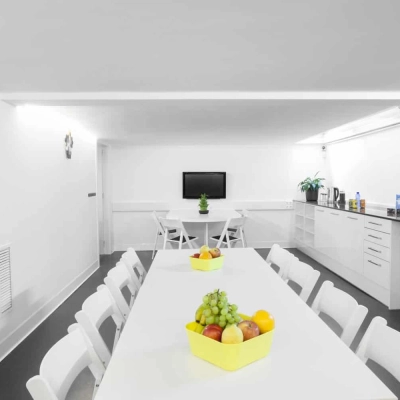 Espacio moderno y luminoso para alquilar una oficina en Carrer de L'Escorial 180, Barcelona Gràcia, con mesas blancas y detalles coloridos.